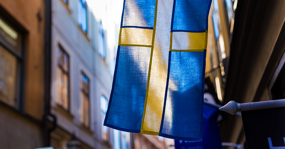 Sverigeflagga på ett hus i en gränd